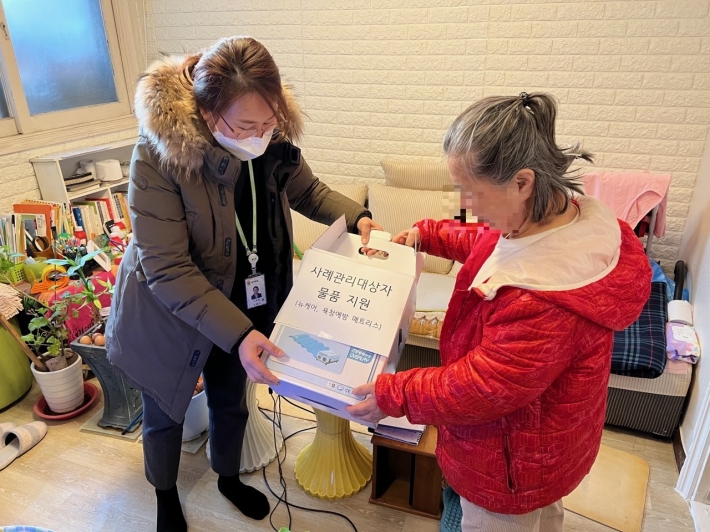 송죽동 맞춤형복지팀장이 사례관리 대상자에게 물품을 전달하는 모습