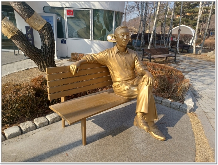 `미스터 토일렛 전 심재덕 수원시장 동상이 벤치에 앉아있다.