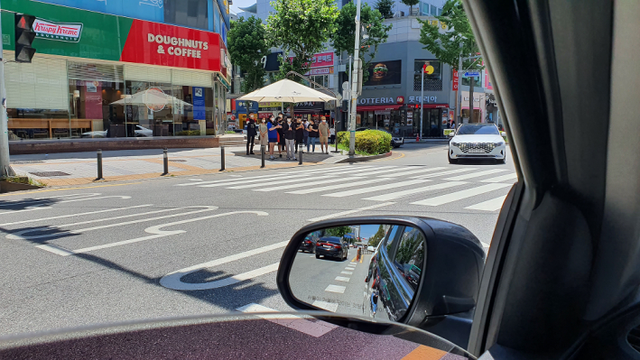 인계로 나혜석거리 입구에 설치된 그늘막. 10명정도가 그늘막 아래 모여있다.