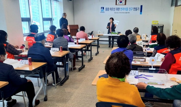 신용남 망포2동이 깜짝 일일강사로 변신하여 홀몸 어르신들께 반려식물 재배법에 대해 설명하고 있다. 