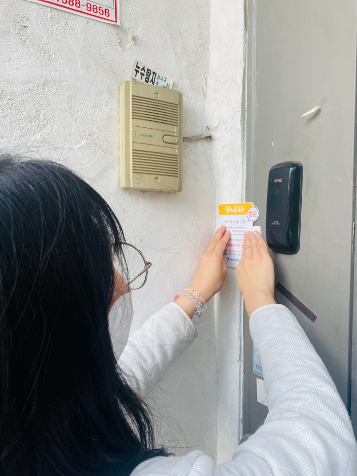 가정방문 알림 스티커를 부착하는 모습
