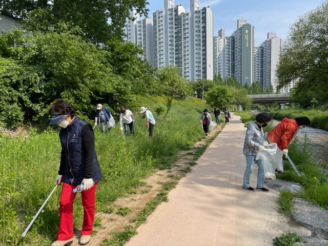 정자1동 주민들이 서호천 산책로를 청소하고 있다.