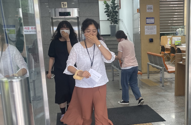민원인과 공무원이 코와 입을 가리고 건물 밖으로 대피하고 있다. 