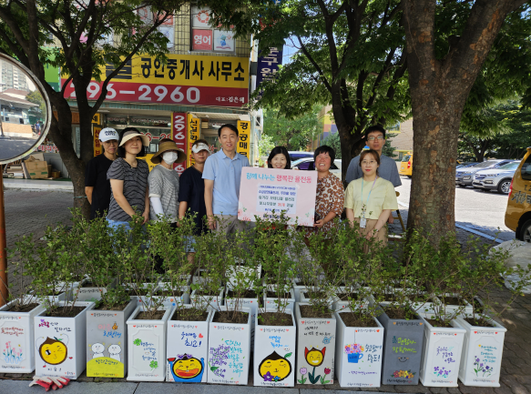 율천동지킴이봉사단이 꽃나무 화분 전달식 이후 기념사진을 촬영하고 있다.