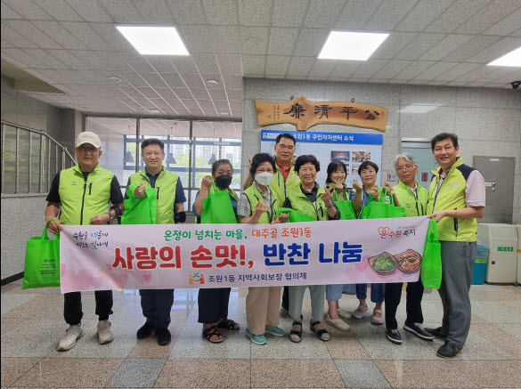 지역사회보장협의체 위원들이 사랑의손맛 반찬나눔 행사 단체사진을 찍고 있다.