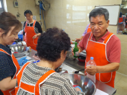 지역사회보장협의체위원들과 참가어르신들이  요리를 함께 만들고 있다