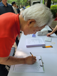 조원주공뉴타운 캠페인에서 한 참가자가 탄소중립을 위한 실천서약서에 서명을 하고 있다.