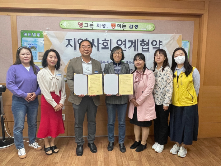 수원 영통중학교와 영통종합사회복지관이 지역사회를 위한 mou를 체결하는 모습이다.