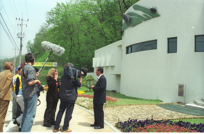 <사진> 2002년 5월 4일 심재덕 시장이 반딧불이화장실 앞에서 독일 2DF-TV와 인터뷰하고 있다.(사진/수원시 포토뱅크)