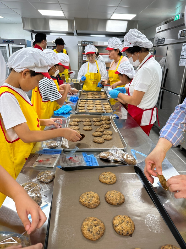<쿠키를 만들고 있는 단원들과 학부모, 봉사자들>