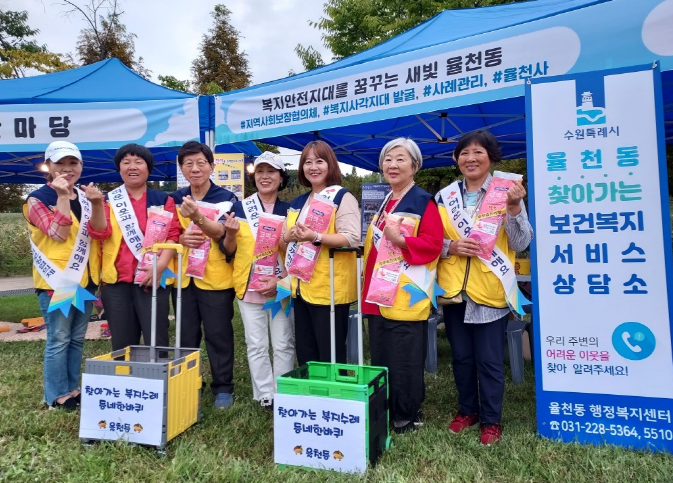 지역사회보장협의체 위원들이 부스 앞에서 복지정보를 안내하고 있다.