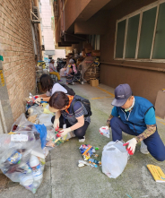 무단투기 단속반이 무단투기자 식별을 위해 봉투를 검사하고 있다.