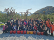 영통1동 주민공감력 향상 농촌체험에 참여한 주민들이 사과 수확 체험을 마치고 사과 바구니와 함께 사진에 담겼다.