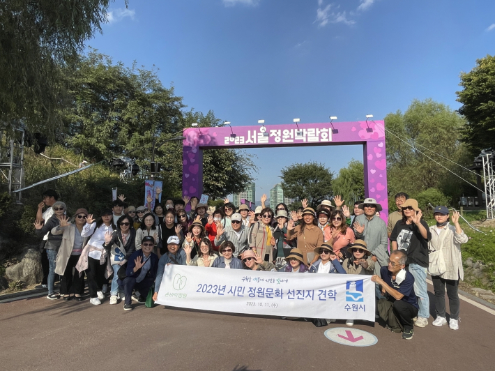 견학 참석자들이 '2023년 서울 정원문화 박람회'에 참석해 단체사진을 촬영하고 있다.     