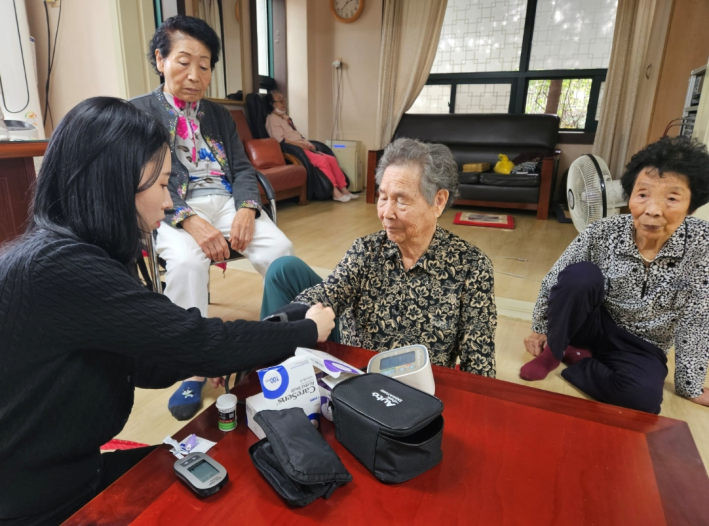 간호직 공무원이 어르신의 혈압을 측정해드리고 있는 모습