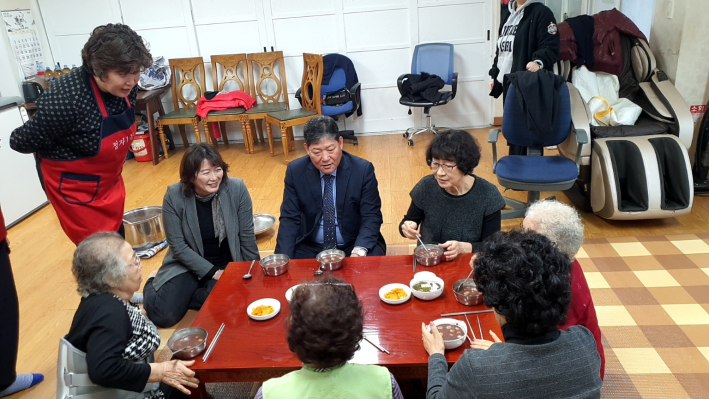 정자1동 주민자치회 위원들이 경로당을 방문하여 직접만든 동지 팥죽을 대접하고 있다