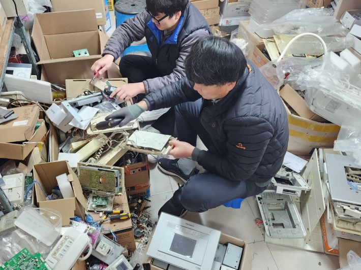 폐품 하나하나를 분해하고 있는 윤진석 새마을지도자협의회장 가족