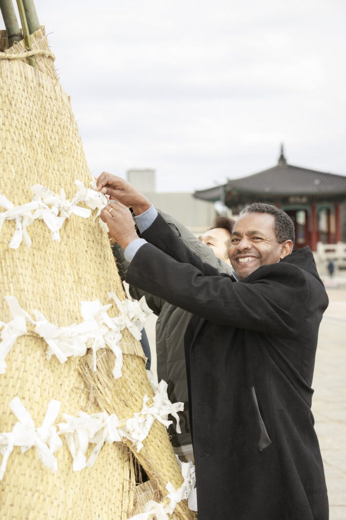 종이에 소원을 적어 새끼줄에 매달고 있는 참가자 모습(사진 수원문화원 제공)