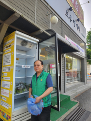 우만1동 새마을지도자협의회 김동준회장이 첫 수확한 상추를 공유냉장고에 진열하고 있다.