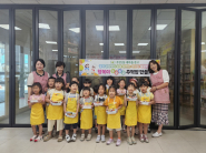 우만1동 새마을문고회 회원들과 예닮어린이집 어린이들이 완성된 주먹밥 도시락을 들고 기념촬영을 하는 모습이다.