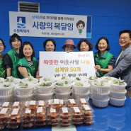 우만1동 김범수 동장과 새마을부녀회 회원들이 활짝 웃고 있다.