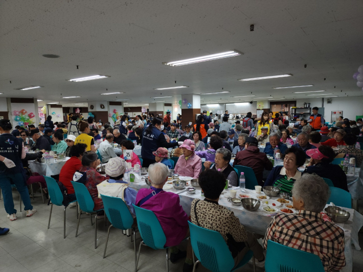 망포2동 경로잔치 행사장에서 어르신들이 식사와 공연을 즐기고 있다. 