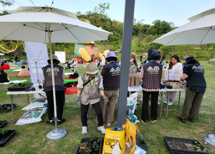 영흥수목원 잔디마당에서 식물을 체험하고 나눠주고 있다.