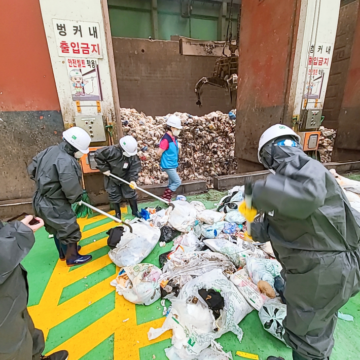 매산동 통장과 직원들이 자원회수시설에서 폐기물 샘플링 작업을 하고 있다.