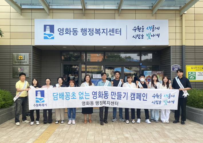 임성진 영화동장이 영화동행정복지센터 정문에서 직원들과 캠페인 사진을 촬영하고 있다.