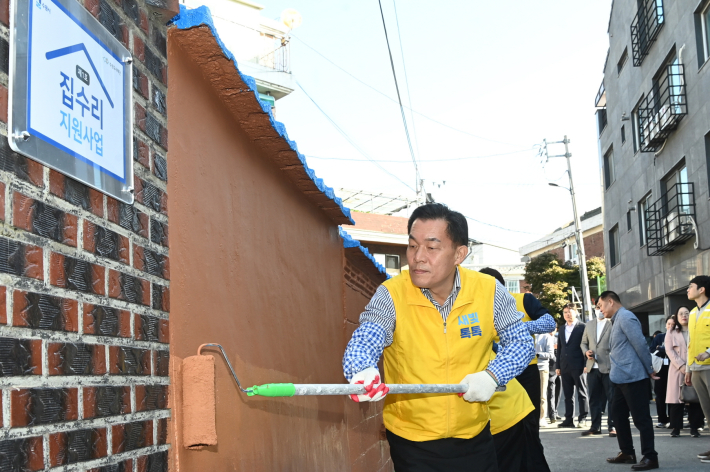 지난해 10월 이재준 수원시장이 1호 새빛하우스(집수리지원사업)의 담장을 칠하고 있다.