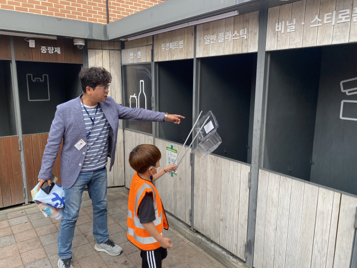 권태건 행정민원팀장이 영화동 자원순환역에서 아이들에게 분리배출 요령을 알려주고 있다.