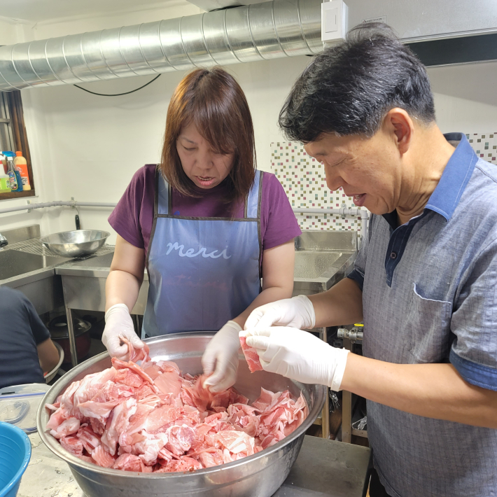 제육볶음을 위해 고기를 손질하는 학부모와 이상민 교장