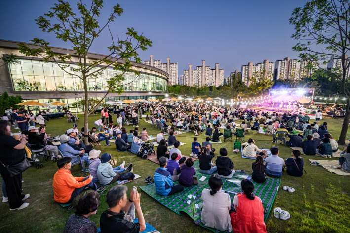 수원시민들이 지난 5월 28일 수원 일월수목원 잔디광장에서 개관 1주년 기념으로 개최된 '별 헤는 가든 음악회'를 즐기고 있다..