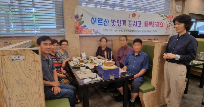 7월 생신을 맞이한 어르신들이 이교수한정식 수원대게에서 식사를 하며  권나희 화서1동 지역사회보장협의체 위원과 기념사진을 찍고 있다.