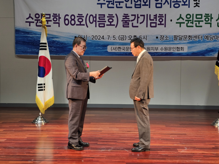 박일문 시인이 `밝아지는 초승달`이 수원문학 신인상에 당선되어 수원문인협회 김운기 회장으로부터 수상을 하고 있다.