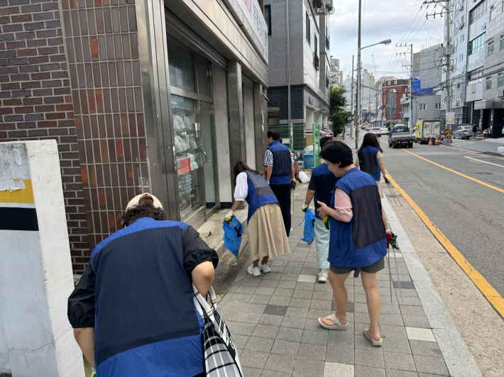 매교동 주민자치 위원들이 길가에 버려진 쓰레기를 줍고 있는 모습