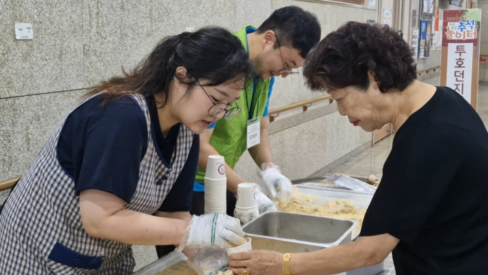 떡을 썰어 어르신들께 나누고 있다.