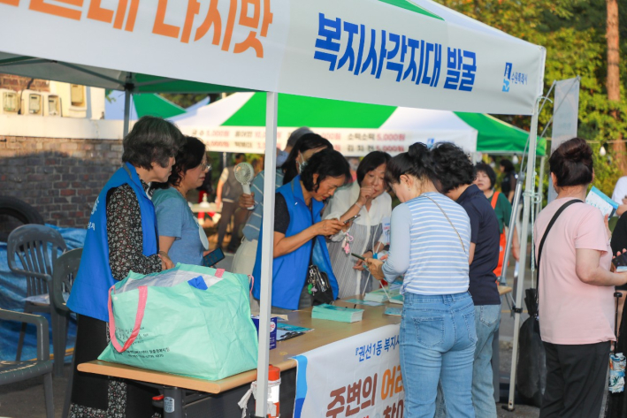 이고선생 축제를 찾은 주민들이 홍보부스에서 '복지위기 알림 앱'을 가입하고 있다