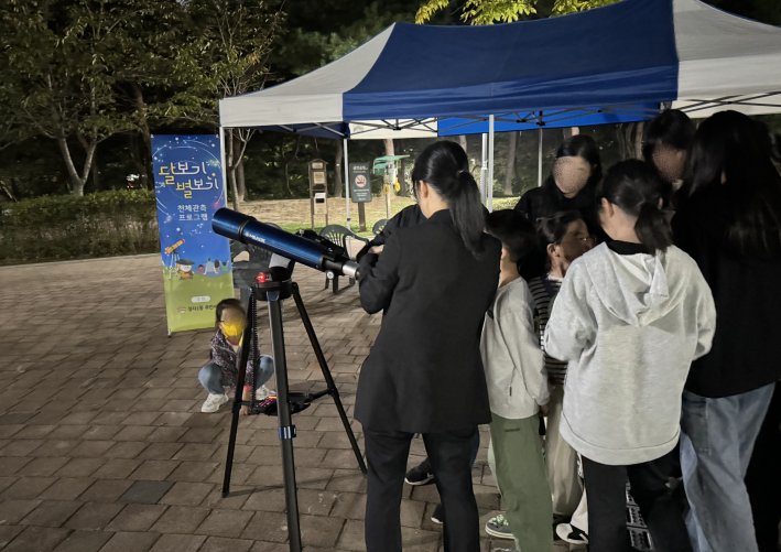 프로그램 참여자들이 천체망원경으로 달을 관측중이다.