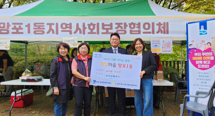 백승혁 SFG사장과 김영희 망포1동장이 갈비탕 50인분 후원 판넬을 함께 들고 있다.