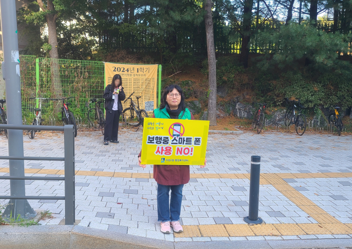 조원2동 새마을부녀회 회원이 통학로에서 안전 홍보 피켓을 들고 있다.