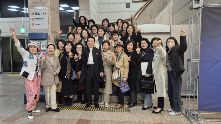 공연 후 단체 기념사진. 가운데 남성이 송흥섭 지휘자.