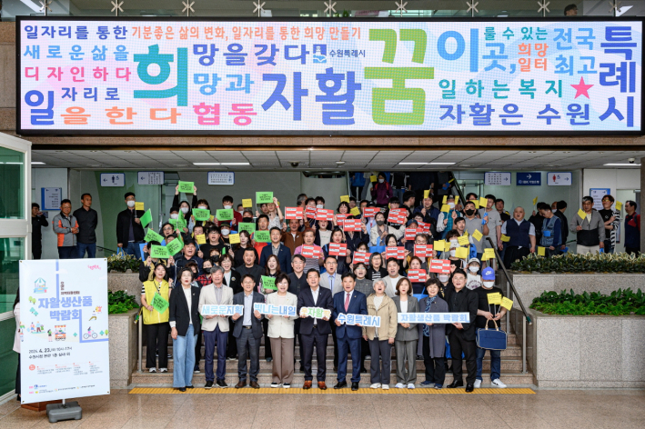 지난 4월 수원시청 본관 1층 로비에서 '자활생산품 박람회'가 열려 참가자들이 기념촬영을 하고 있다.