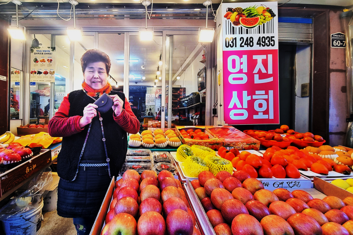 만든 카드지갑을 들고 자신의 과일가게 앞에서 사진을 찍은 허정숙님의 모습이다. 