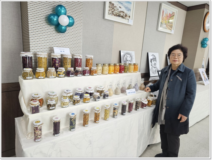 꽃차를 만든 제품을 전시하는 수강생이 꽃차에 대하여 설명을 하고 있다.