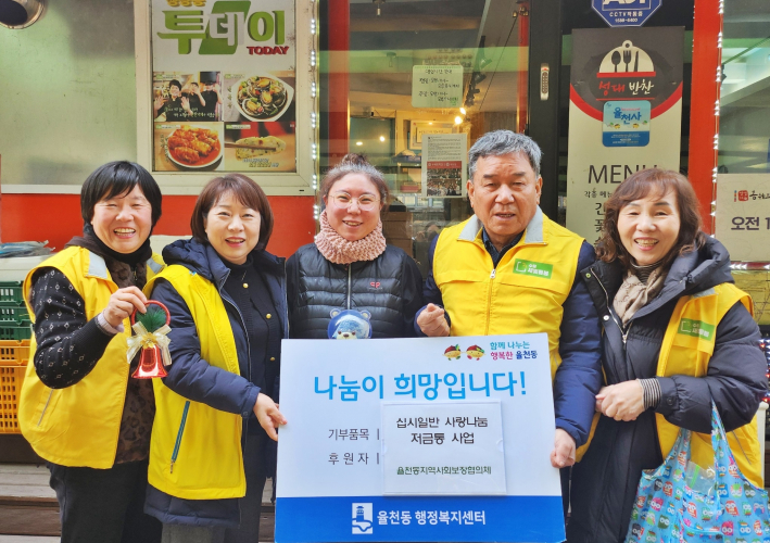 십시일반 사랑나눔 저금통을 전달받고 사진을 찍고 있다.