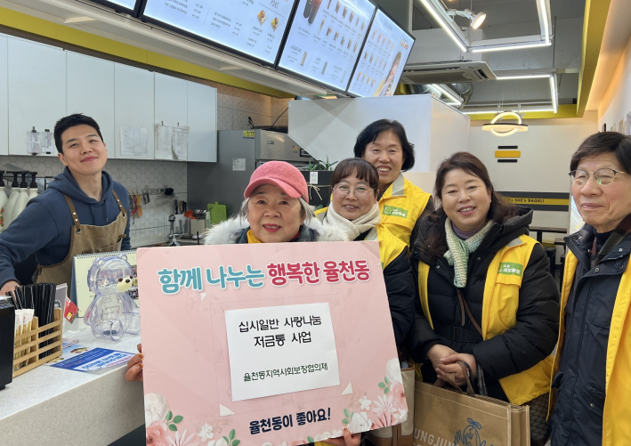 십시일반 사랑나눔 저금통을 전달받고 사진을 찍고 있다.