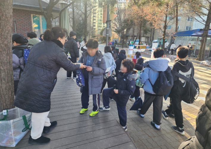 장안구 조원2동 새마을문고 회원들이 겨울방학 책읽기 행사를 학생들에게 홍보하고 있다.