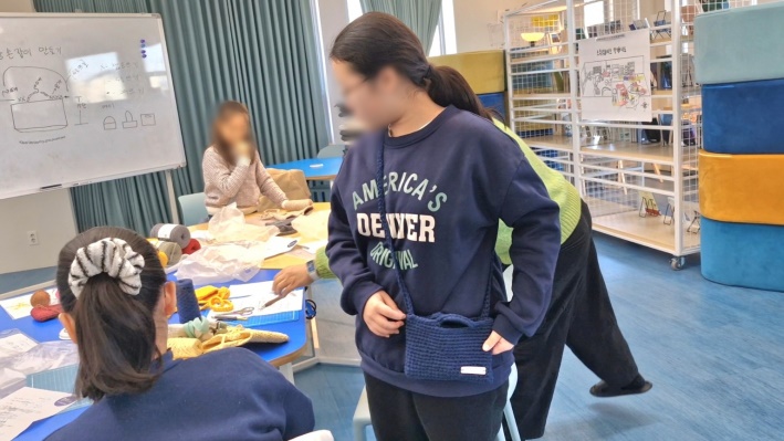 완성된 백을 어깨에 메고 있는 수험생