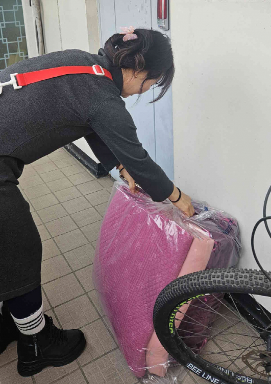 매탄4동 지역사회보장협의체 위원이 세탁된 이불을 배달하고 있다.